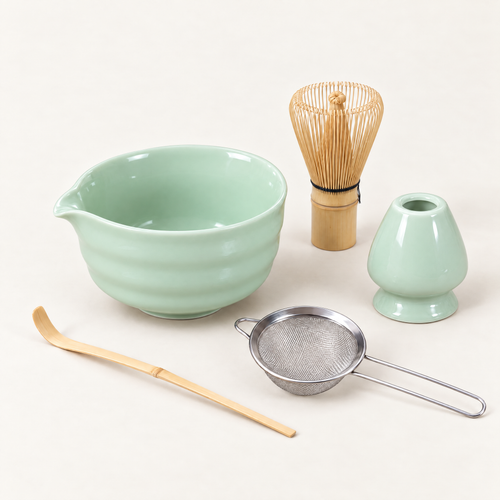 Celadon matcha set with ceramic bowl, bamboo whisk, whisk stand, scoop and strainer on an off-white background
