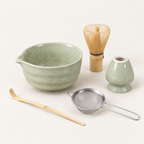Speckled sage matcha set with ceramic bowl, bamboo whisk, whisk stand, scoop and strainer on an off-white background