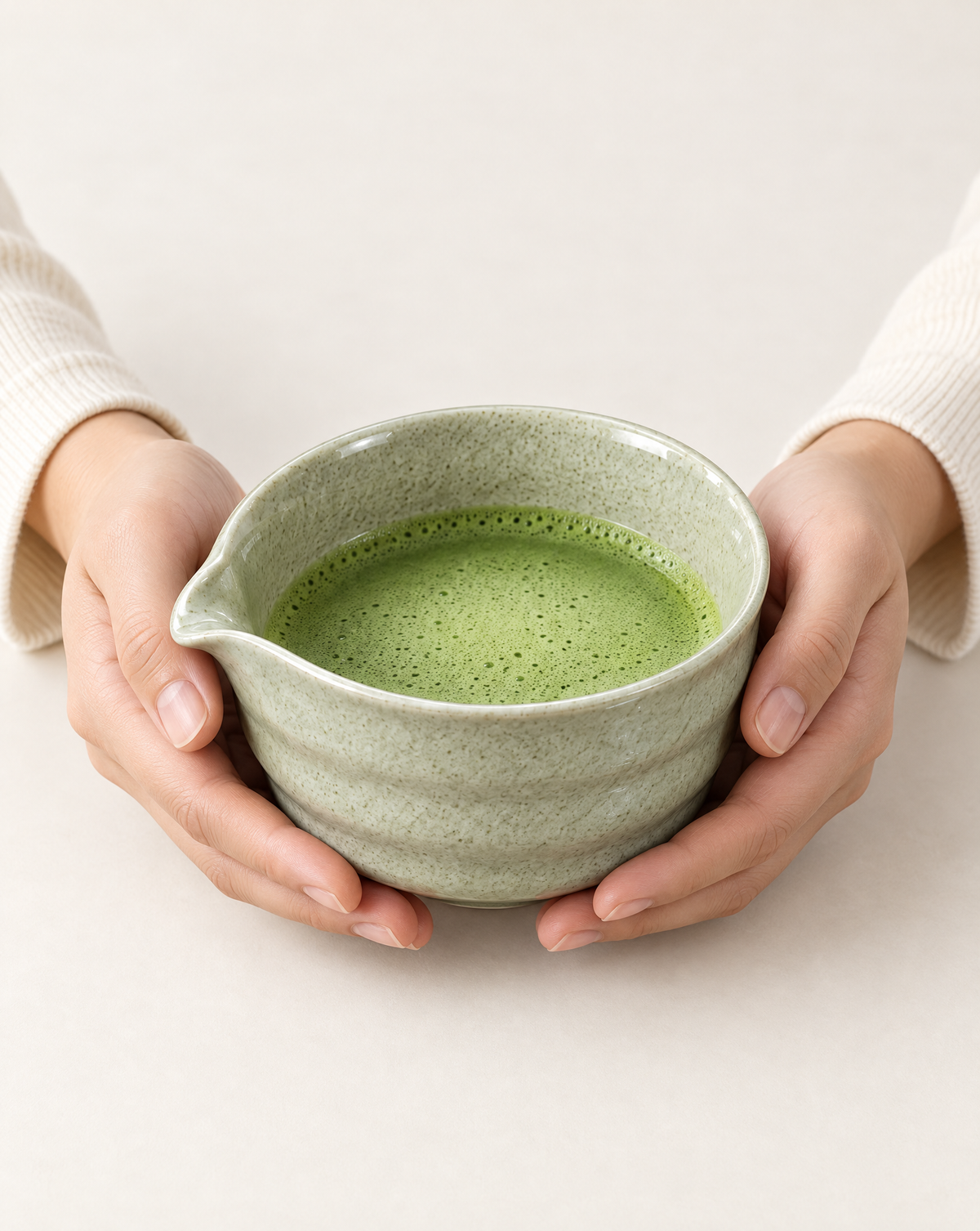 Finished frothy matcha held in the Tokyo Whisk Speckled Sage bowl